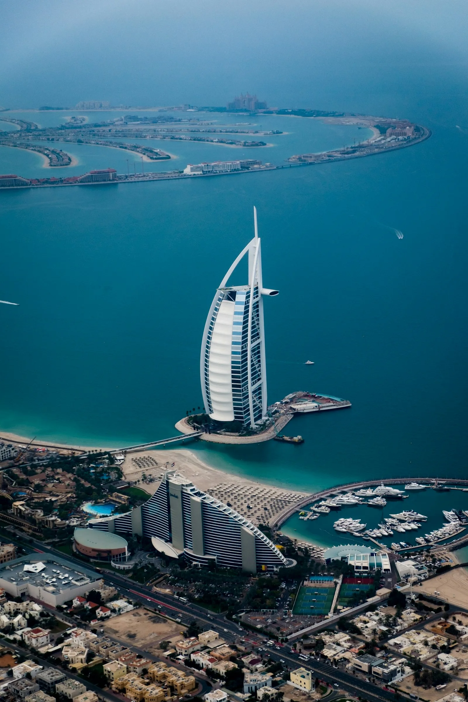 Aerial view of Dubai&rsquo;s coastline and city grid &mdash; the emirate whose private sector has two years to move to agentic AI